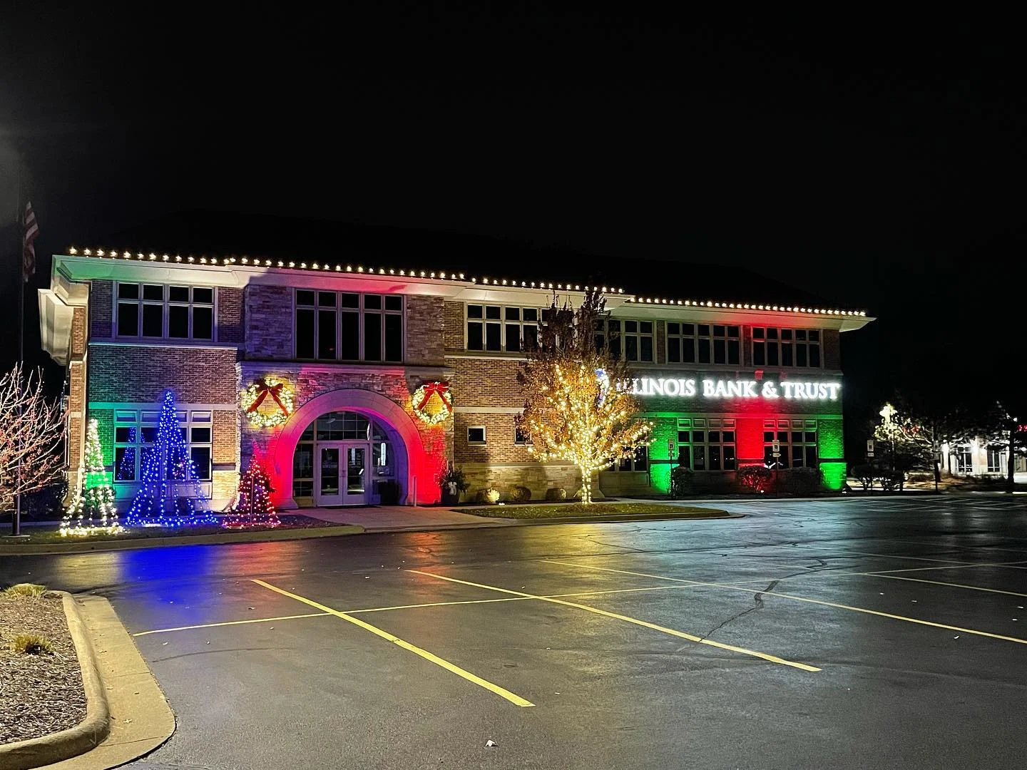 Green Acres holiday lighting installation at Illinois Bank & Trust featuring colorful LED lights and decorated trees